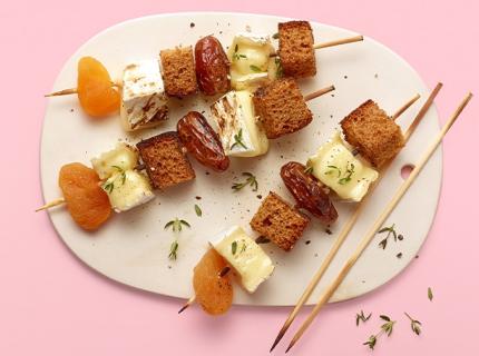 Brochette de brie fondu, pain d’épices, dattes et abricots secs